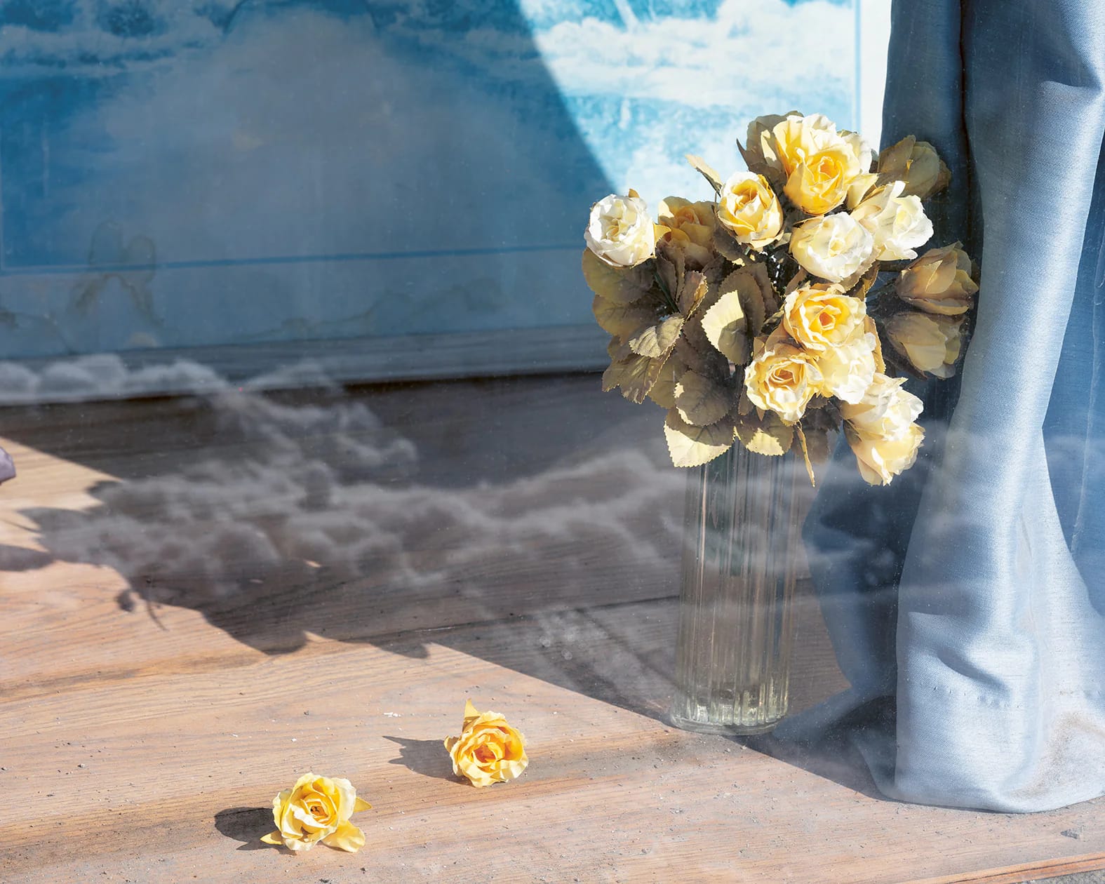 Yellow roses in vase and a reflection of clouds