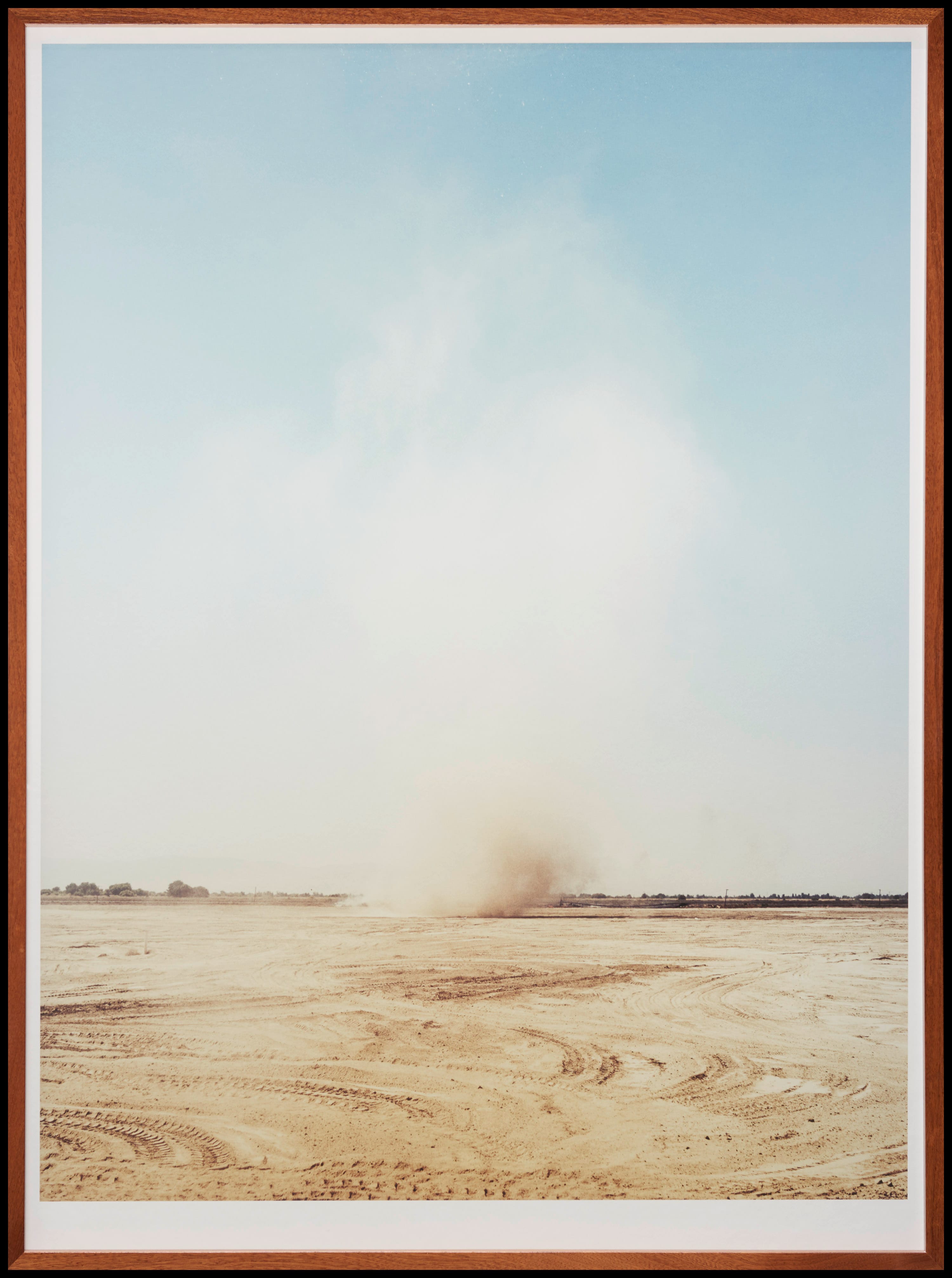 Een zandstorm in woestijnachtig landschap met blauwe lucht.