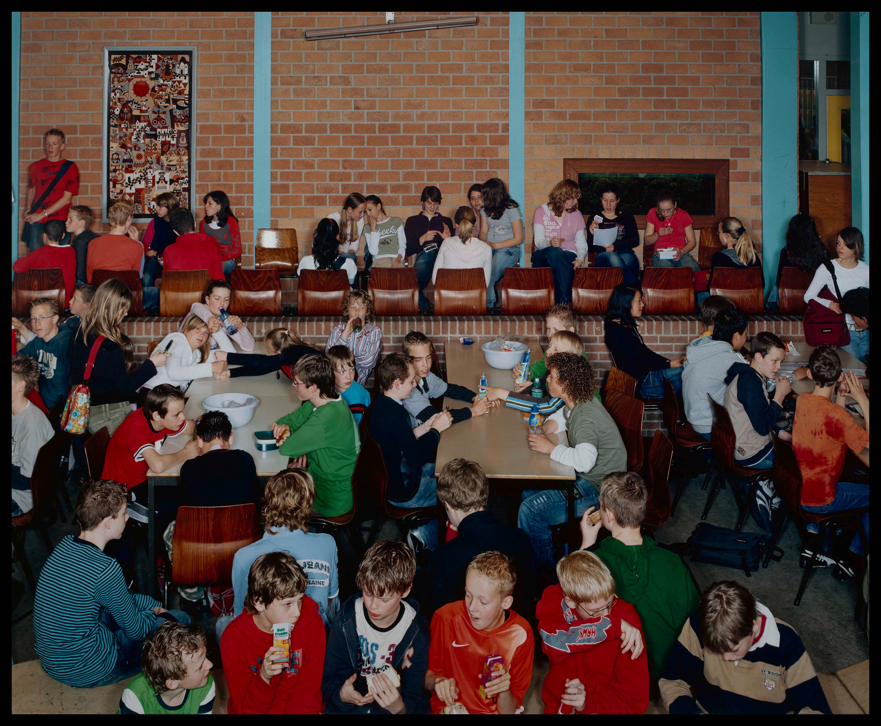 Groep middelbare scholieren in de aula tijdens pauze.