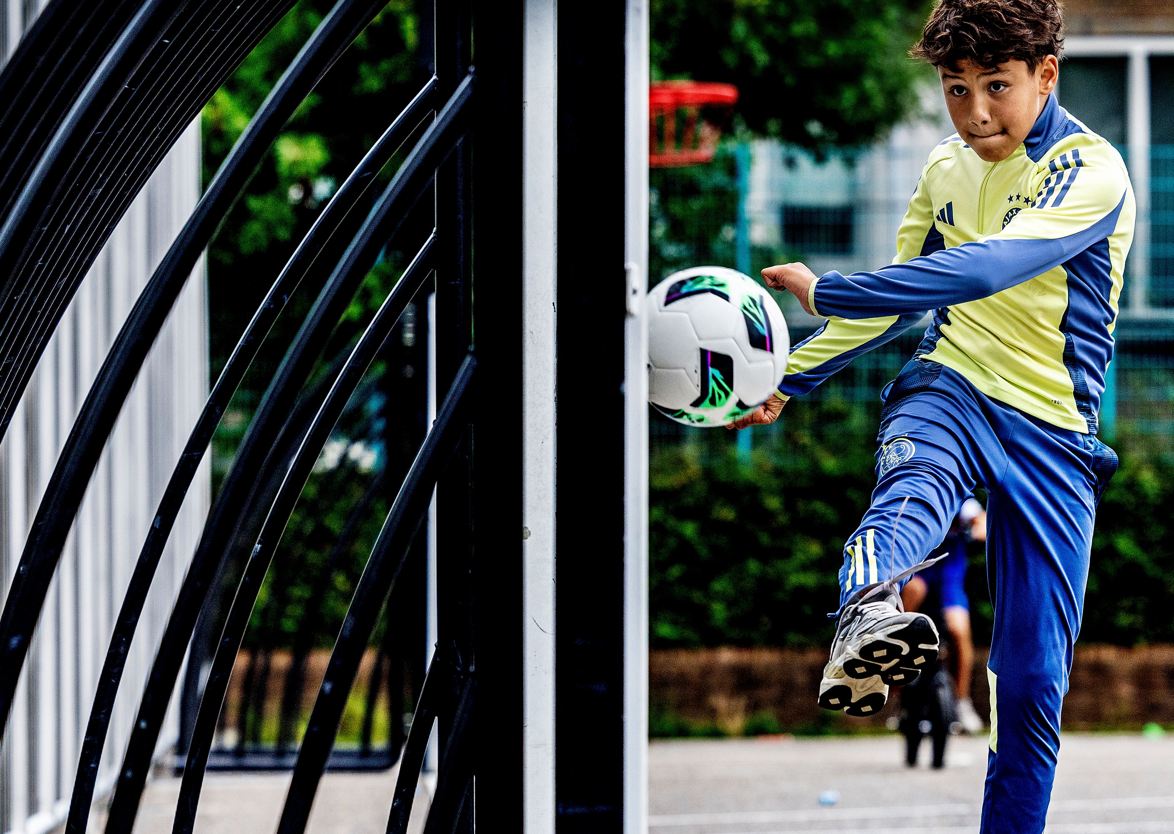 Image of a boy in a tracksuit playing football.