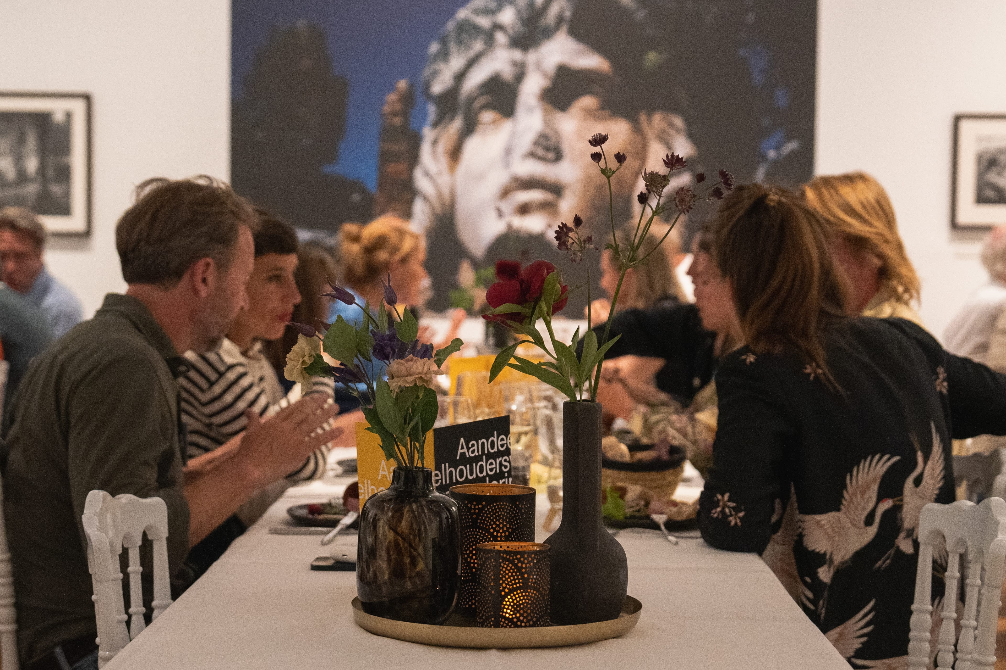 Table with people talking with a big piece of art in the back