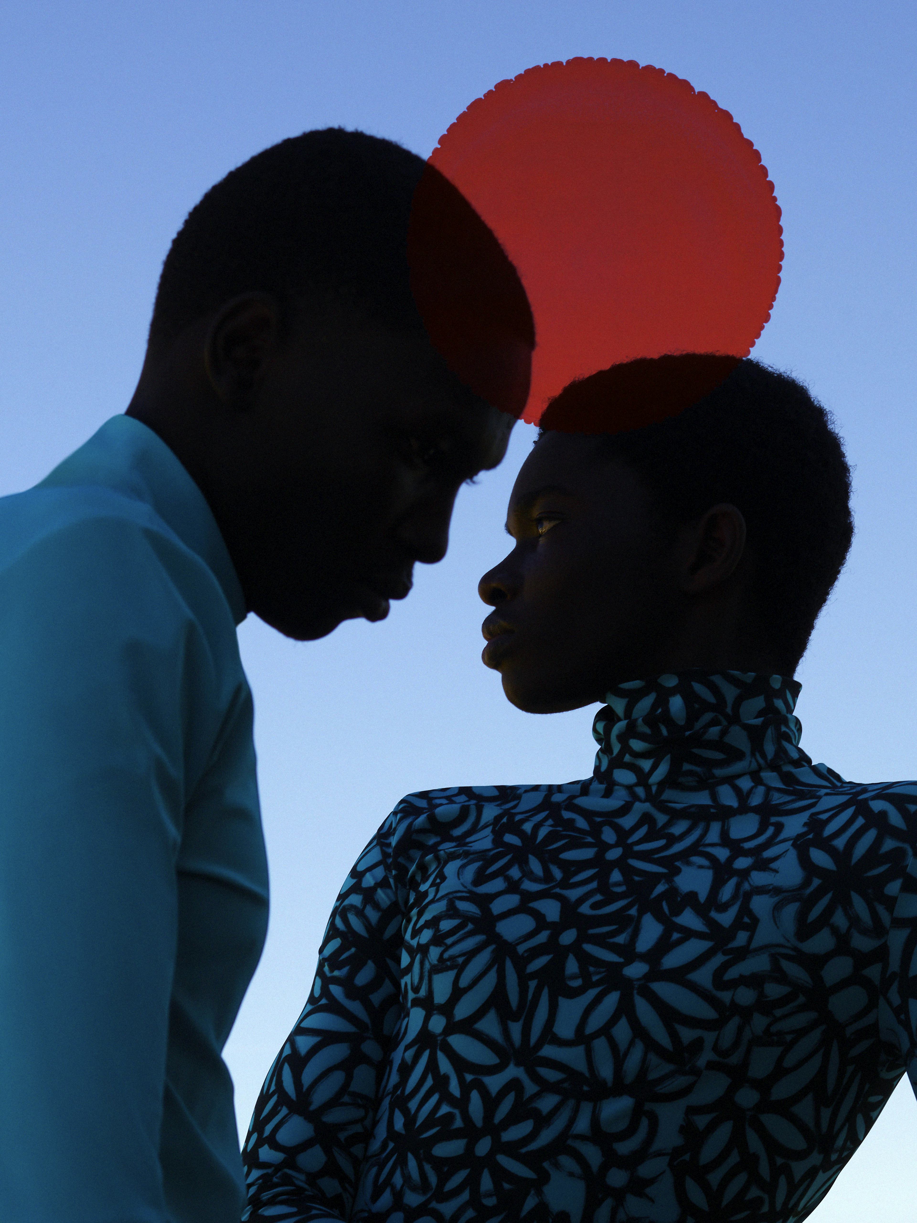 Two people looking to each other with a big red moon in the background