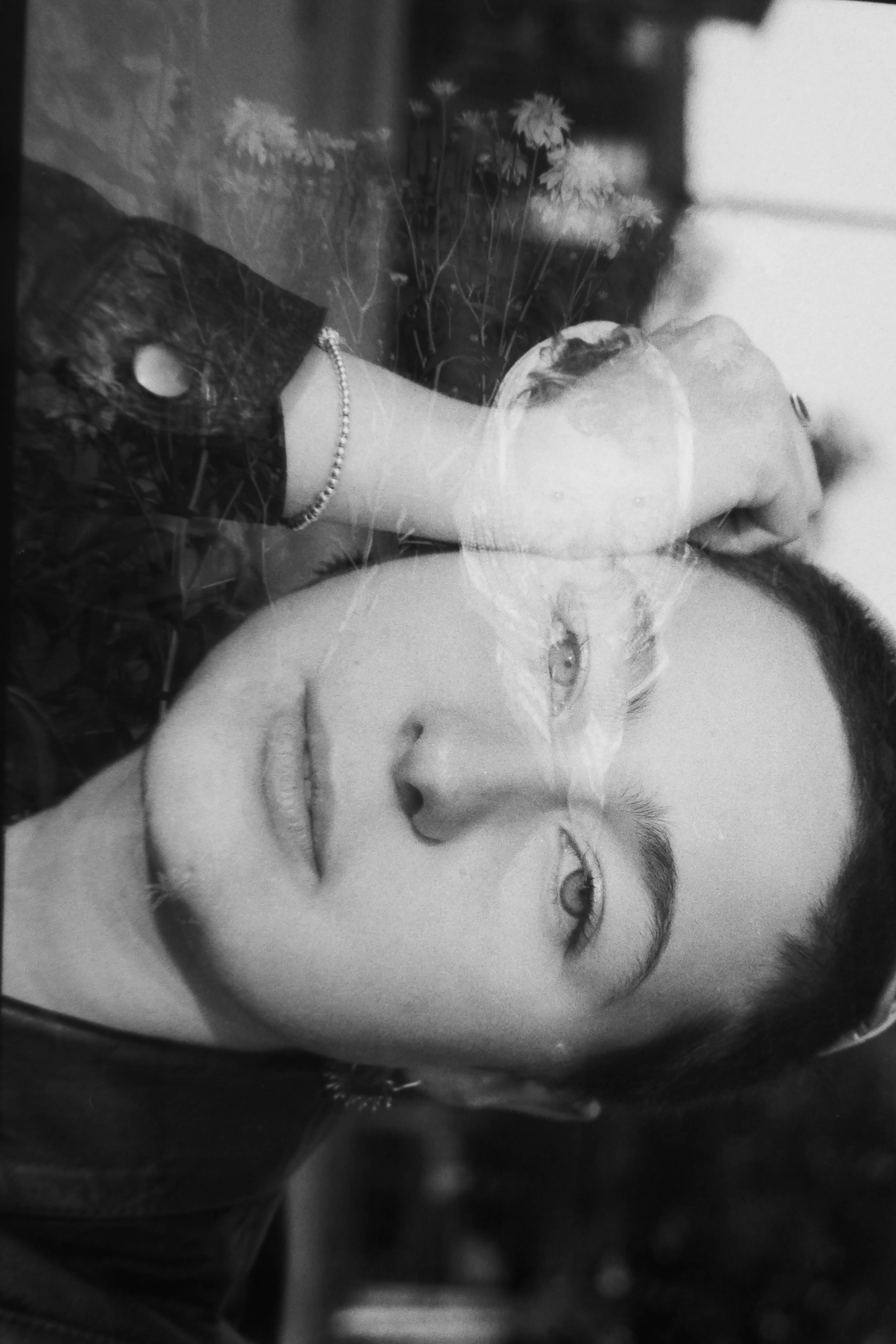 Woman looking in camera double exposure BW