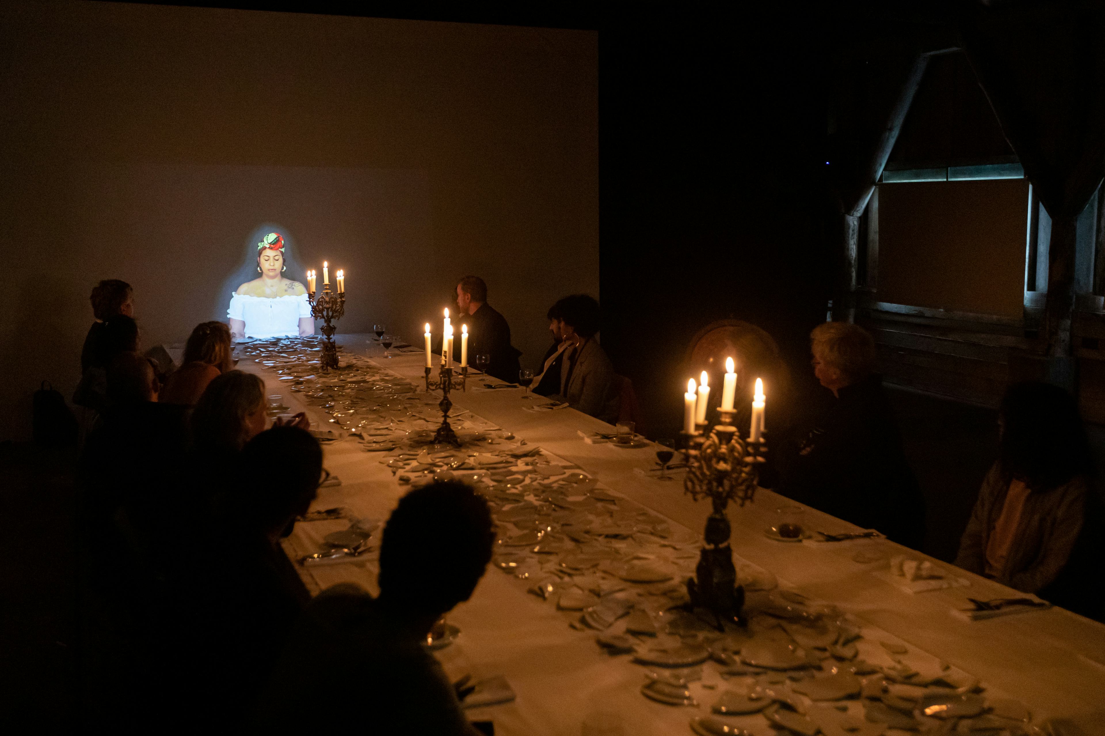 People sitting at a long table in a dark room