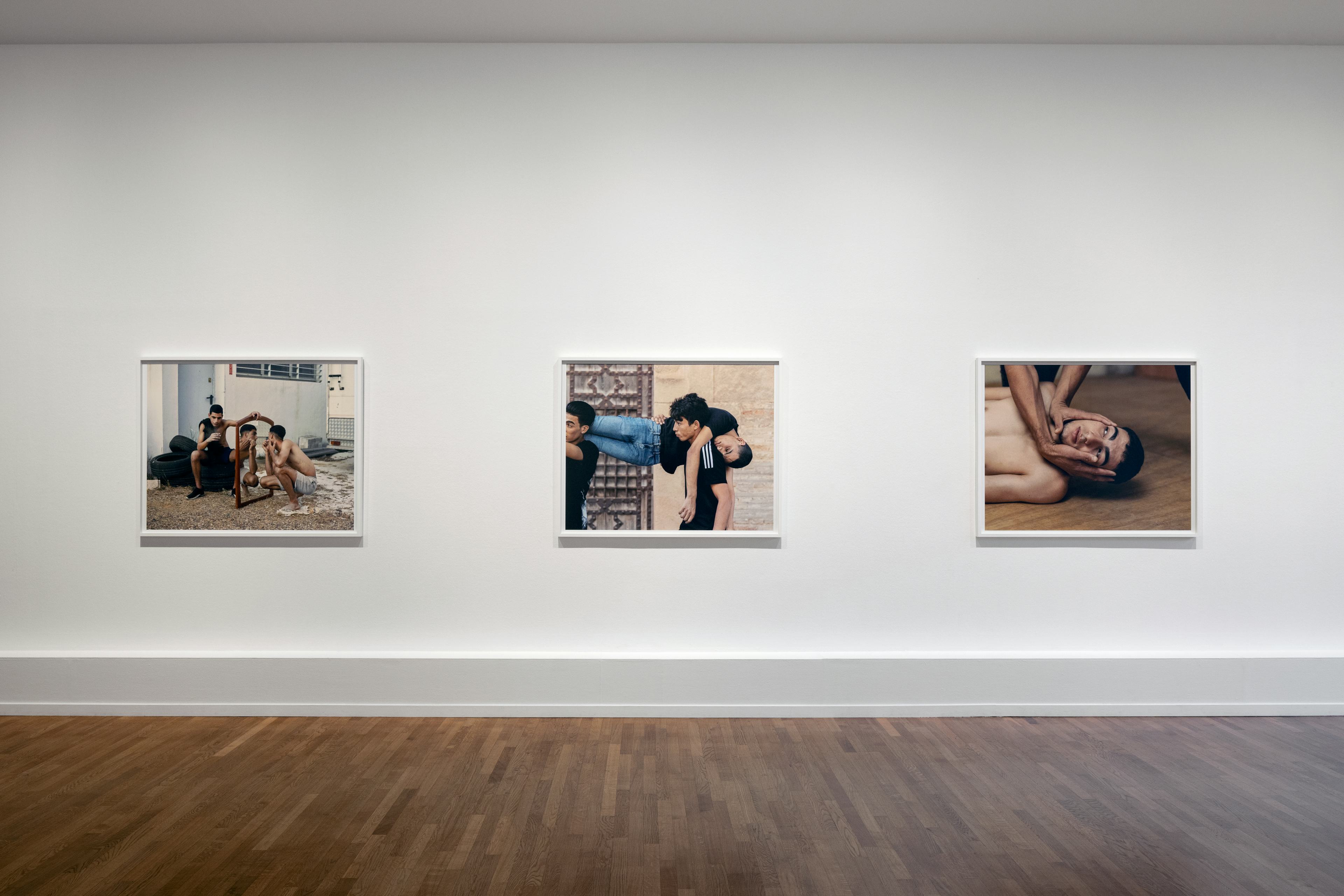 Image of photos hanging in a white exhibition space