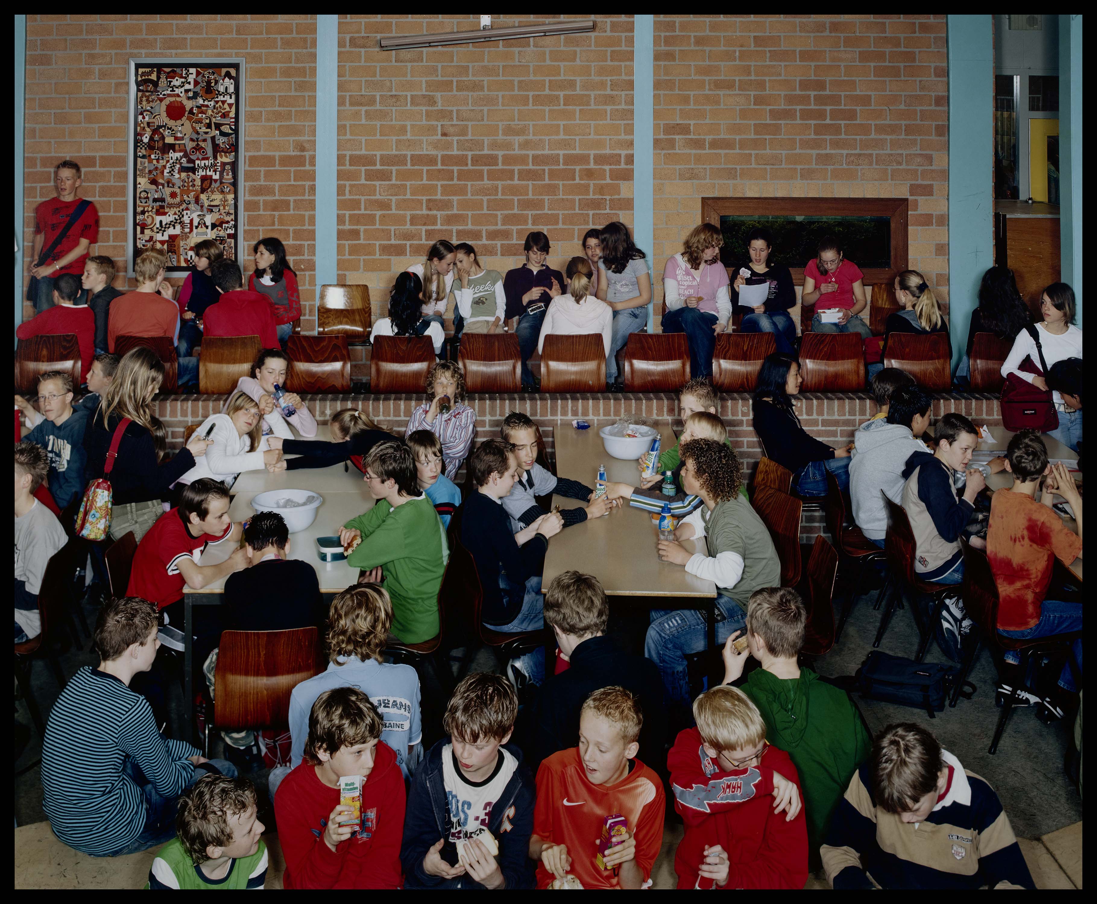 Groep middelbare scholieren in de aula tijdens pauze.